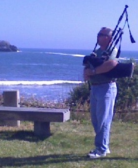 Bruce Locken playing bagpipes by the ocean at Crescent City